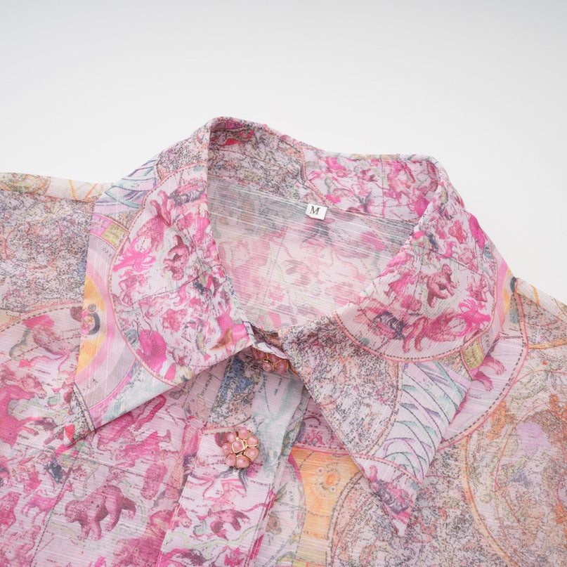 A young girl wearing a cherry pink shirt and skirt set with a pattern print design the top and bottom match creating a coordinated outfit