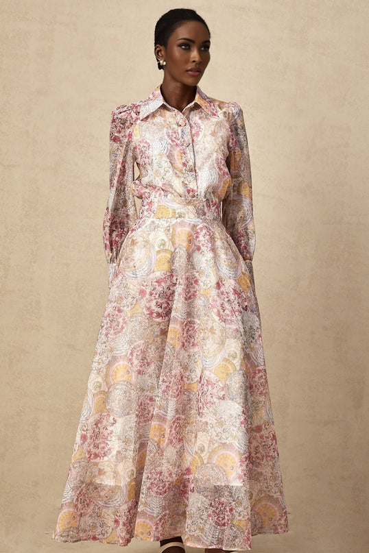 A young girl wearing a cherry pink shirt and skirt set with a pattern print design The top has short sleeves and the skirt falls to knee length Both pieces feature a matching cherry pattern throughout