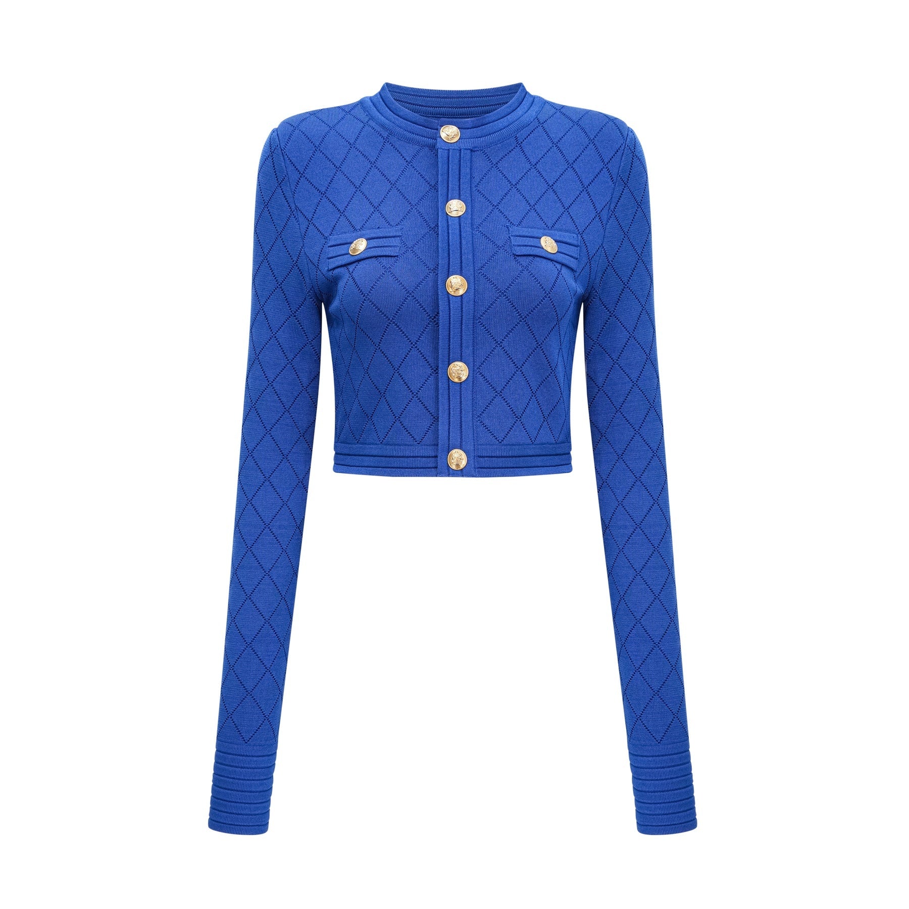 A young woman wearing a blue knitted two piece outfit consisting of a long sleeve top with button details and a matching skirt