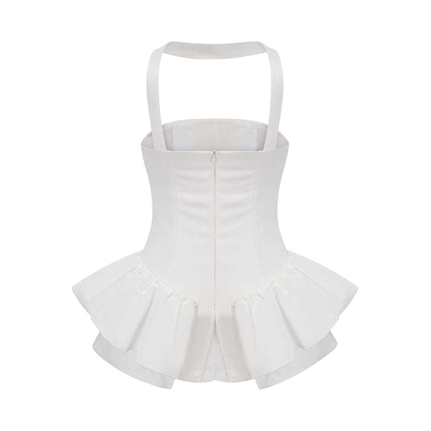 A young woman wearing a white halterneck mini dress with ruffled details standing against a plain background