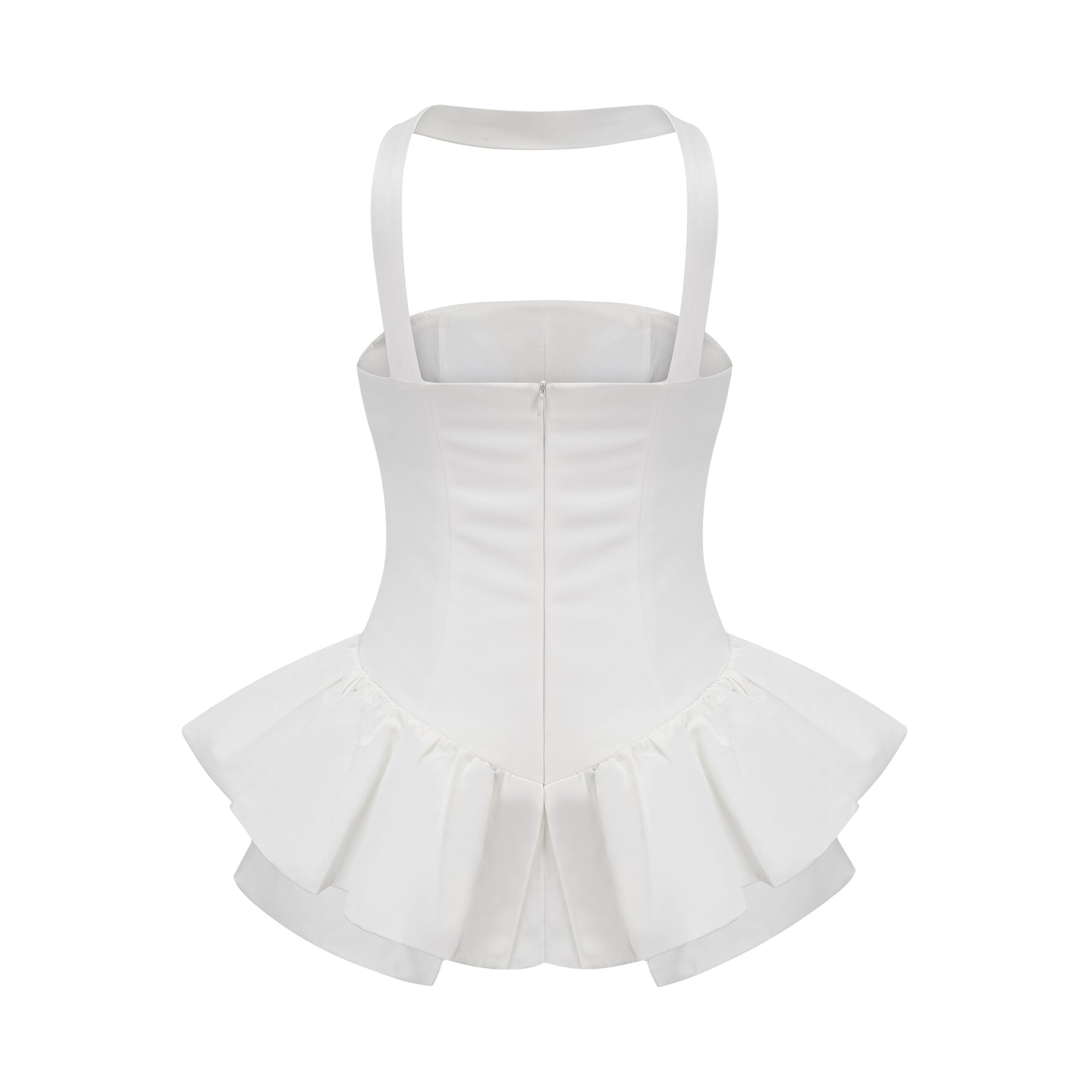 A young woman wearing a white halterneck mini dress with ruffled details standing against a plain background