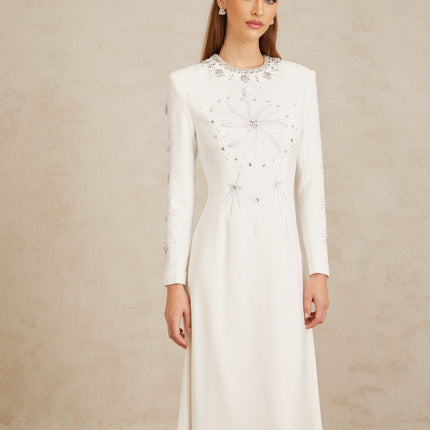 Aloïse White Embellished Maxi Gown in White color with crystal and rhinestone embellishments, round neck, long sleeves, fitted waistline, and flared hem