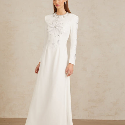 Aloïse White Embellished Maxi Gown in White color with crystal and rhinestone embellishments, round neck, long sleeves, fitted waistline, and flared hem