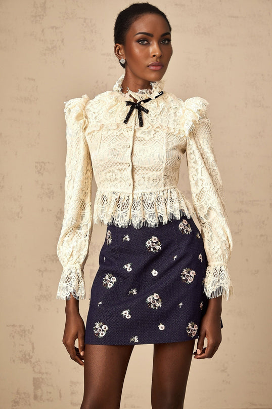 Anaelle blouse in off white featuring a bow detail and floral lace pattern