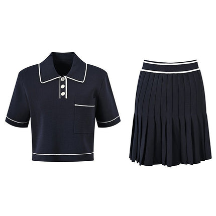 Anita wearing Black polo top with pleated skirt and white accents