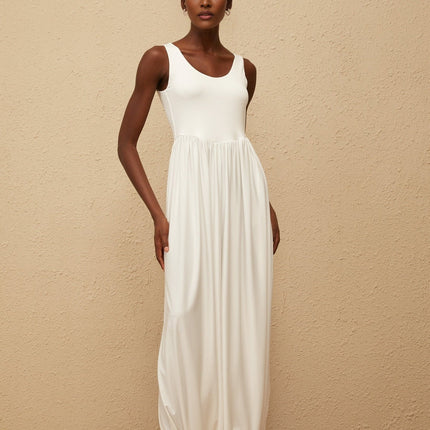 Barbara Maxi Dress in White Terylene Fiber Sleeveless Scoop Neck Wide Straps Fitted Waistline Pleated Skirt Side Slits Semi-Sheer Elegant Chic Modern Maxi Length