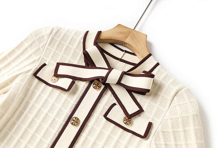 Beige knit A-line dress with brown piping and bow-tie detail