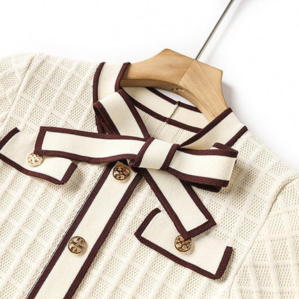 Beige knit A-line dress with brown piping and bow-tie detail