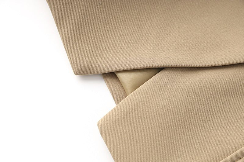 Beige tailored double-breasted blazer with gold button accents and belted waist