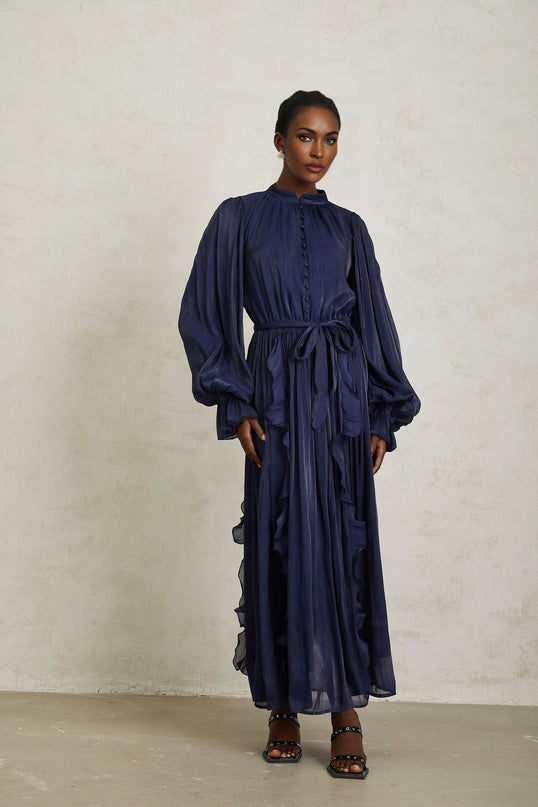 Benedetta Maxi Dress Dark Blue Ribbon Tie-Neck Puff Sleeves Ruffled Trim Tied Waist Glossy Finish Fully-Pleated Maxi Length Rear Zip Fastening 100% Terylene Fiber