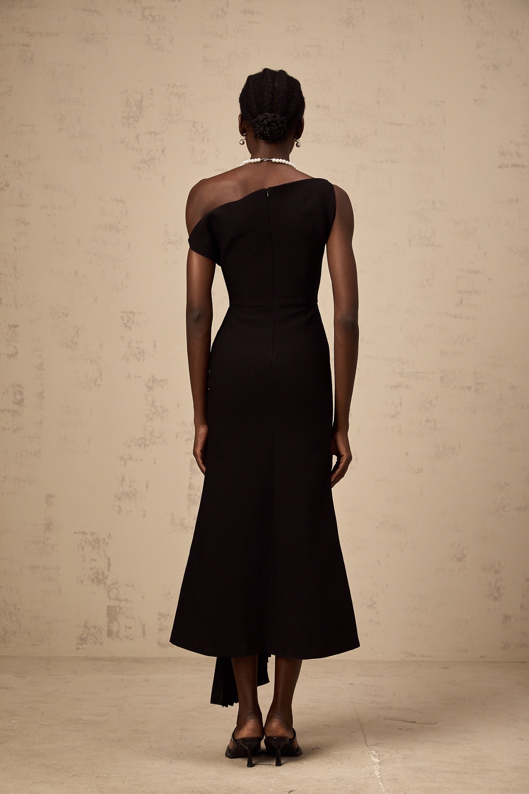 Black asymmetric draped midi dress with a flowing silhouette