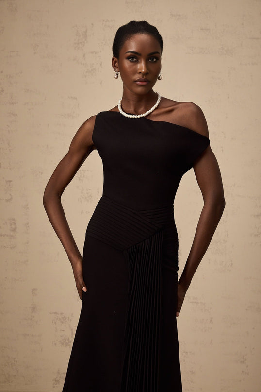 Black asymmetric draped midi dress with flowing fabric and uneven hemline