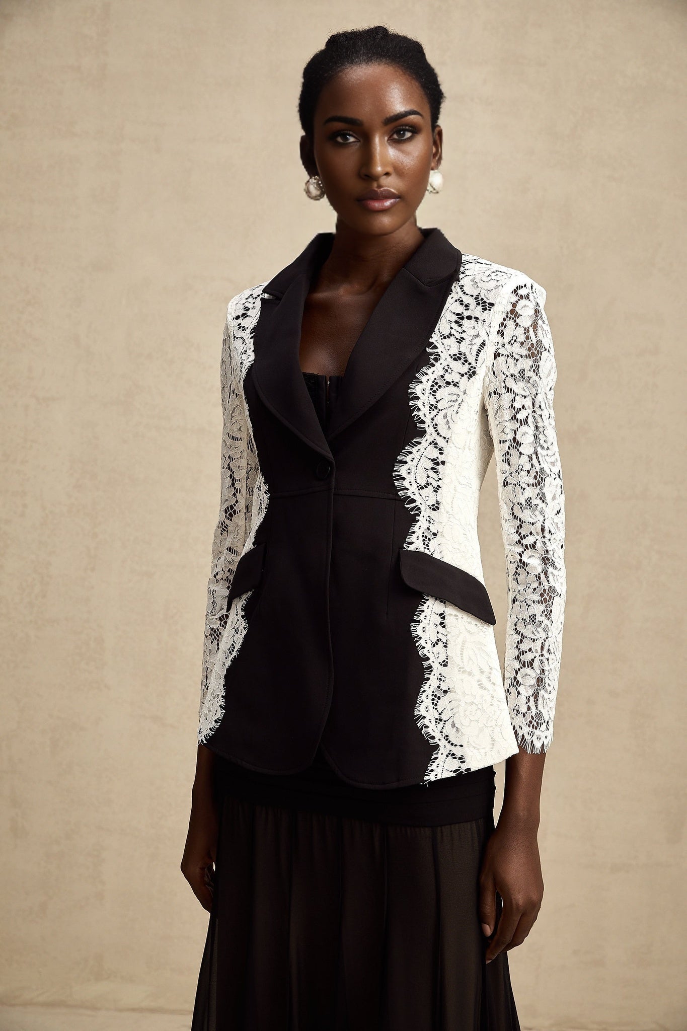 Black blazer with contrasting white lace trim on lapels and cuffs featuring color block design