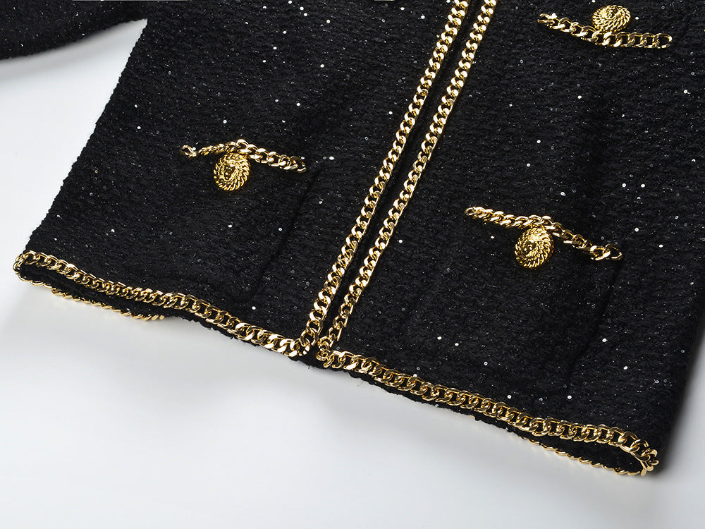 Black cropped boxy jacket with sparkling accents and gold chain trim