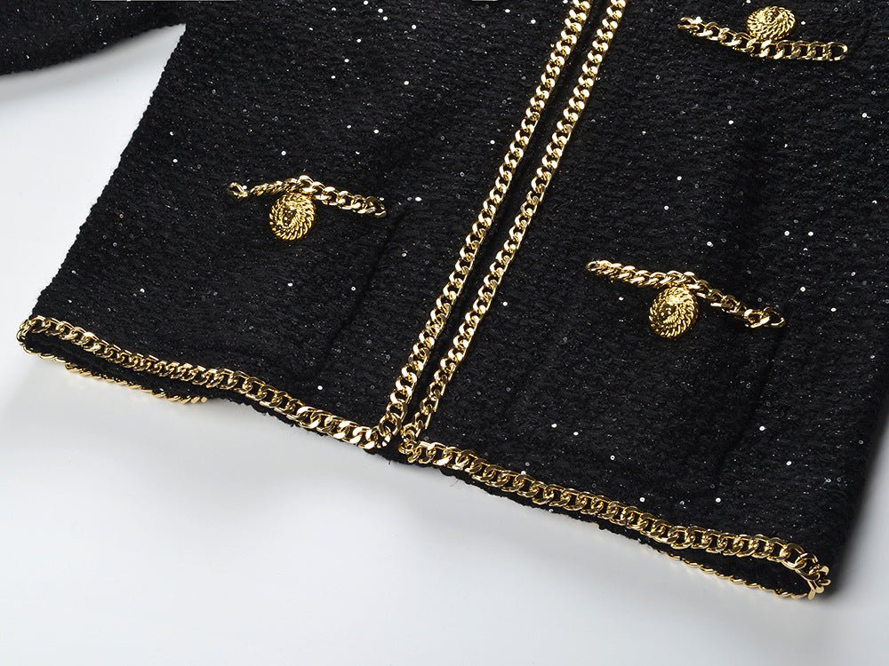 Black cropped boxy jacket with sparkling accents and gold chain trim