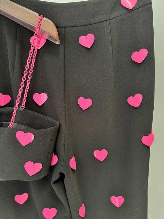 Black cropped top and flared pants with heart pattern and pink accents