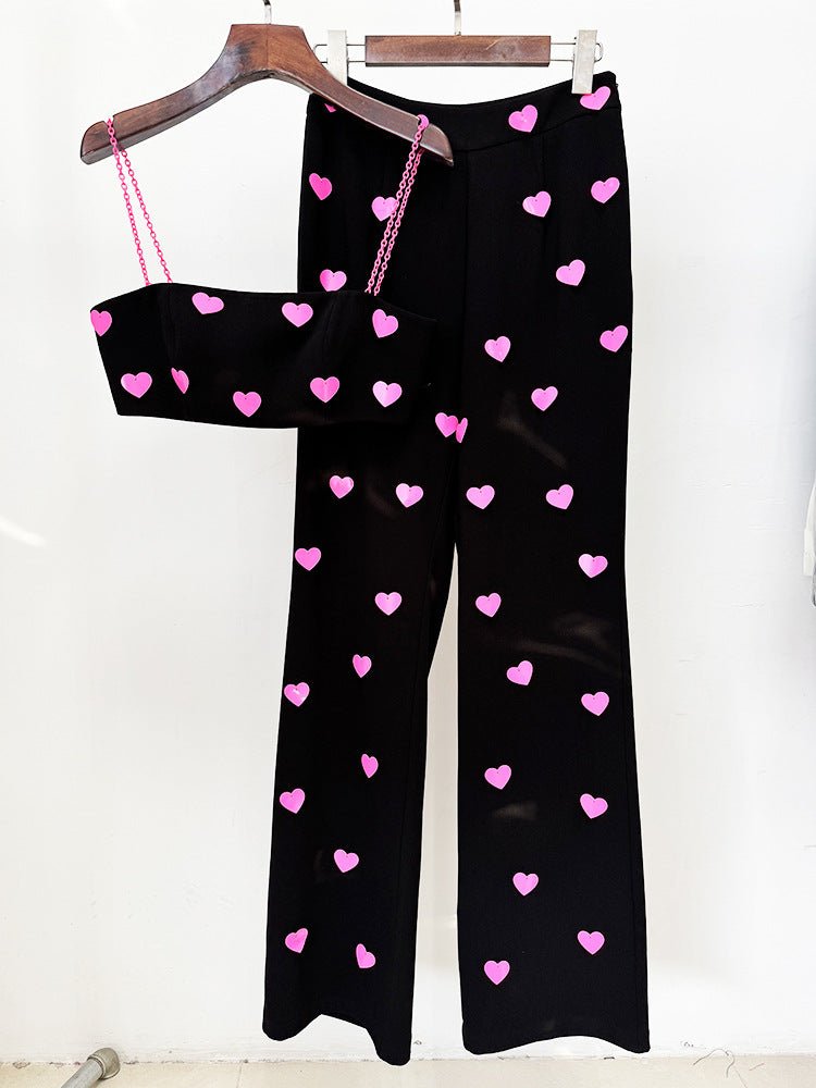Black cropped top and flared pants with heart pattern and bold contrast in pink accents