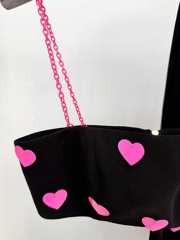 Black cropped top and flared pants with heart pattern and pink accents