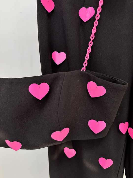 Black cropped top and flared pants with heart pattern and pink accents