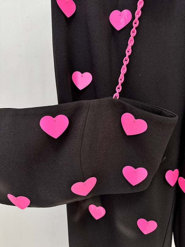 Black cropped top and flared pants with heart pattern and pink accents