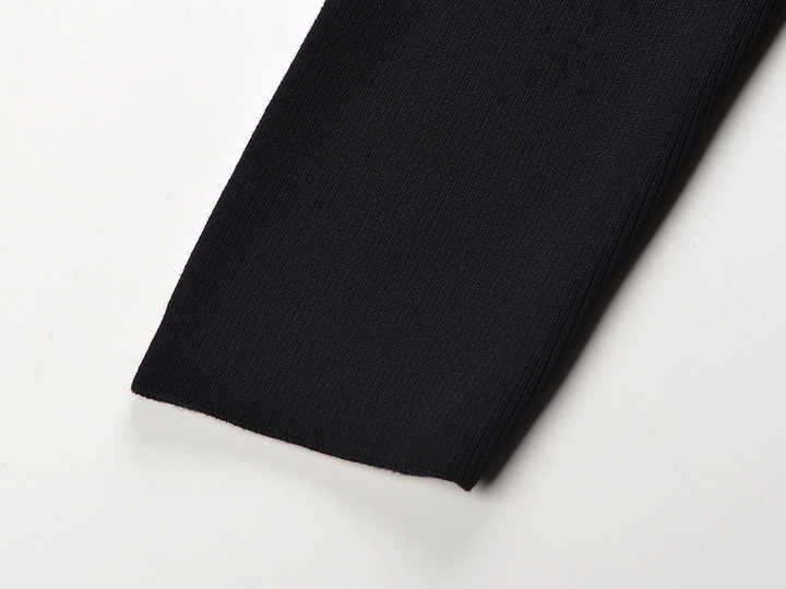 Black knit sweater with feather embellishments and stylish buttons