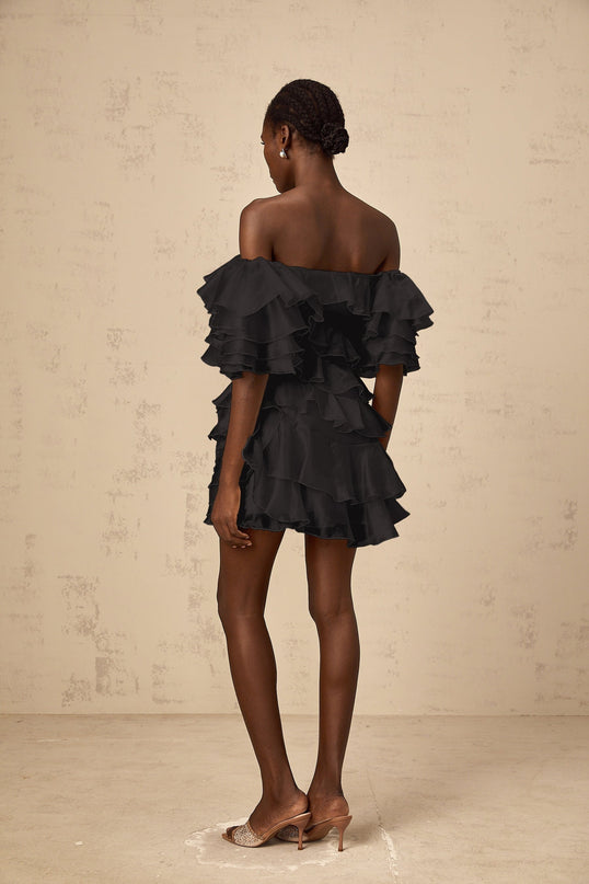 Black mini dress with asymmetric design and flounce detail featuring cerise accents