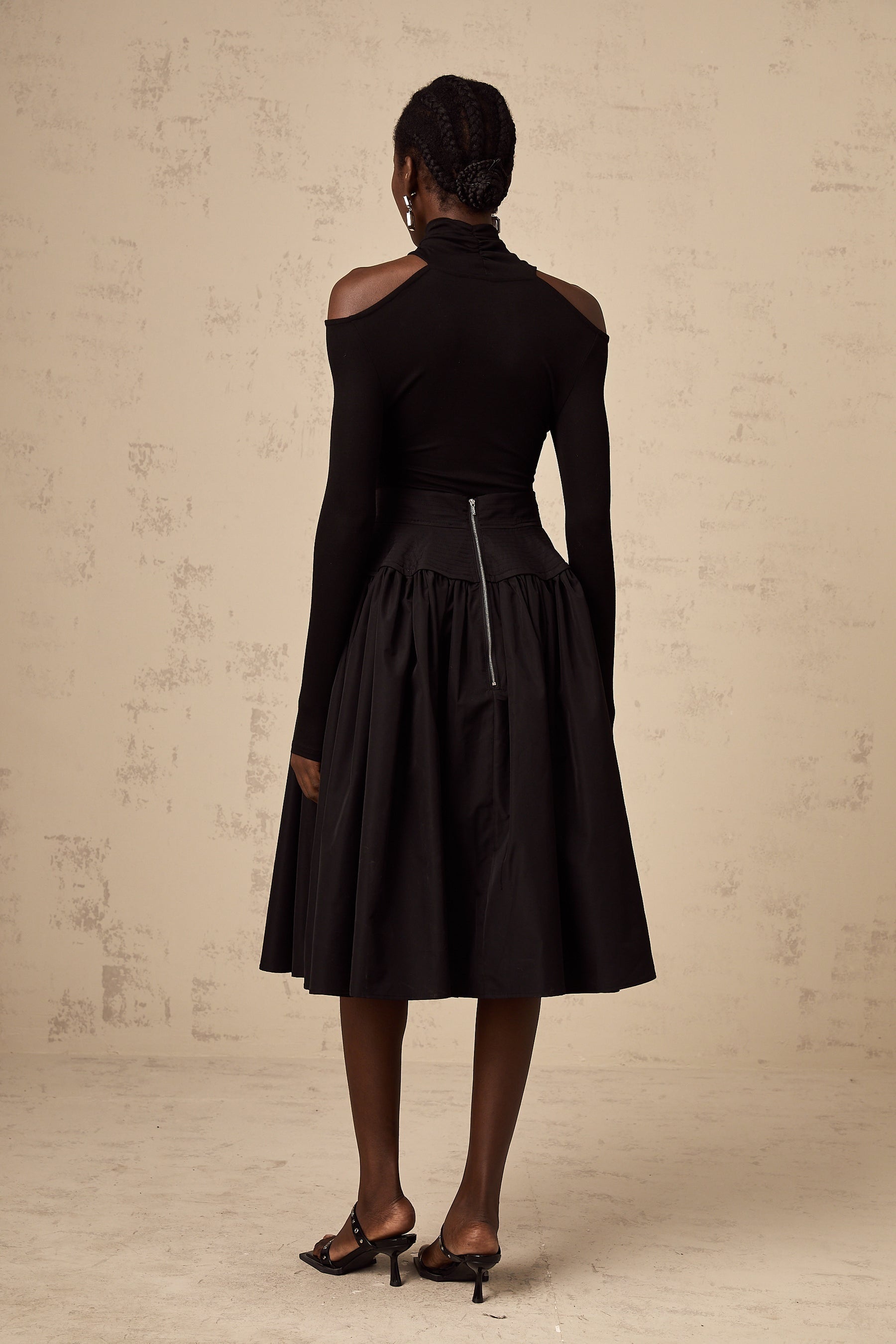 Black pleated midi skirt with flared silhouette named Pauline