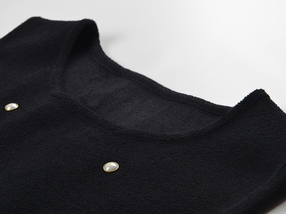 Black sleeveless dress with pearl embellishments and ruffle hem