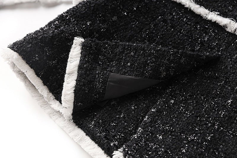 Black tailored blazer with shorts double-breasted belted waist white accents structured fitted silhouette chic sophisticated look tweed fabric gold-tone buttons trim semi-formal events modern twist classic styles