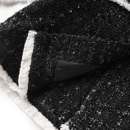 Black tailored blazer with shorts double-breasted belted waist structured fitted silhouette chic sophisticated look tweed fabric texture gold-tone buttons trim semi-formal events modern twist classic styles