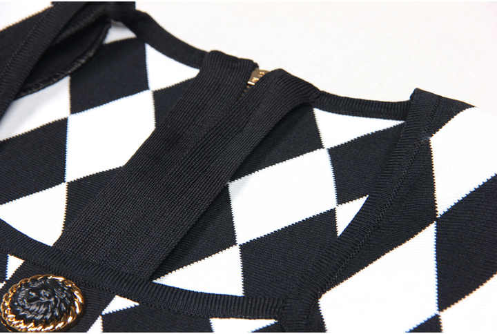 Black and white harlequin pattern fitted dress with gold buttons