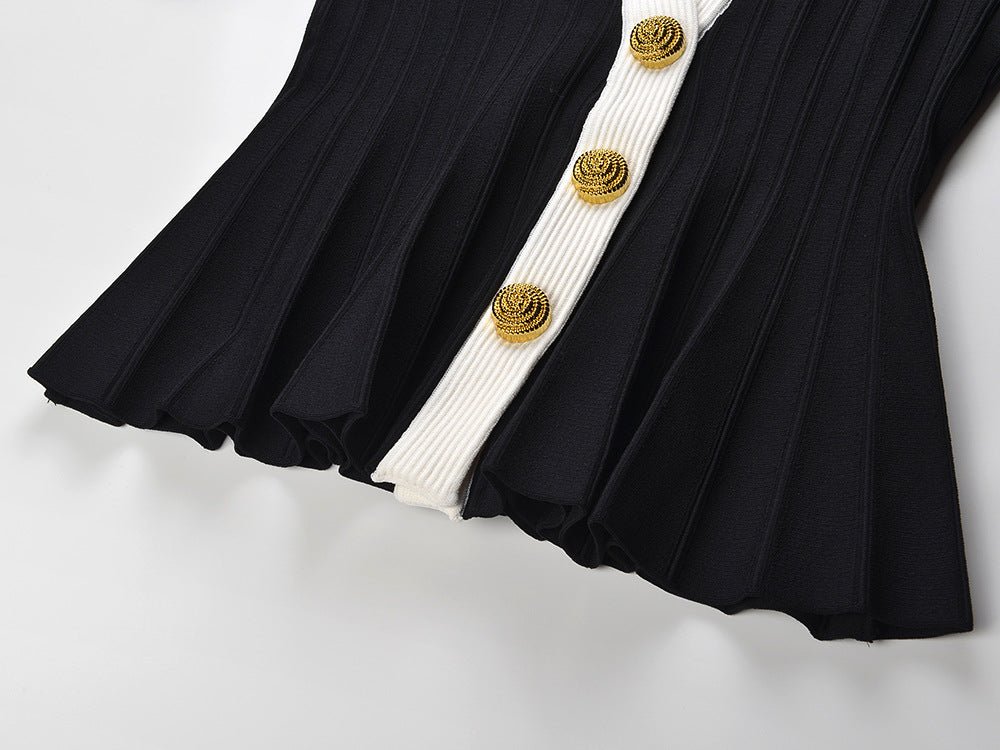 Black and white peplum style top with vertical ribbed texture and gold button embellishments