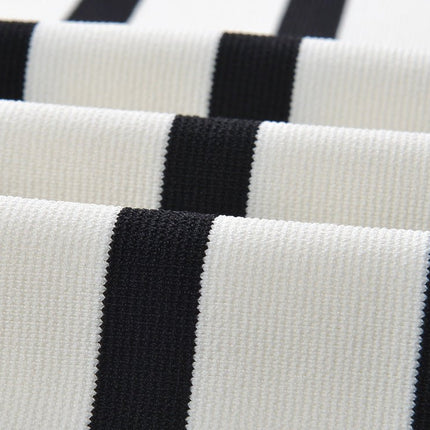 Black and white striped sleeveless body-con knit top with gold button accents on shoulders