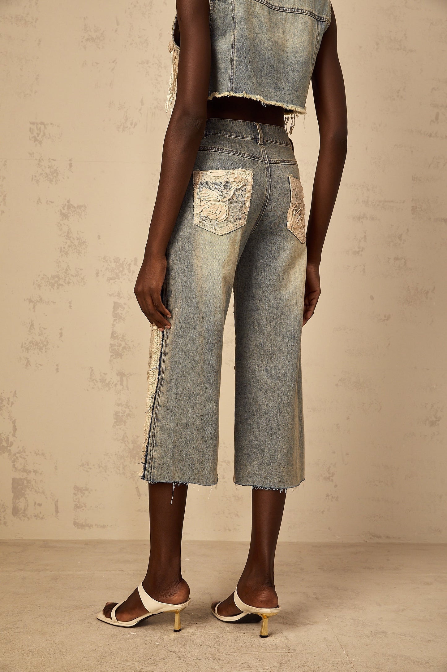 Blue denim jeans with floral lace panels and Amaryllis branding