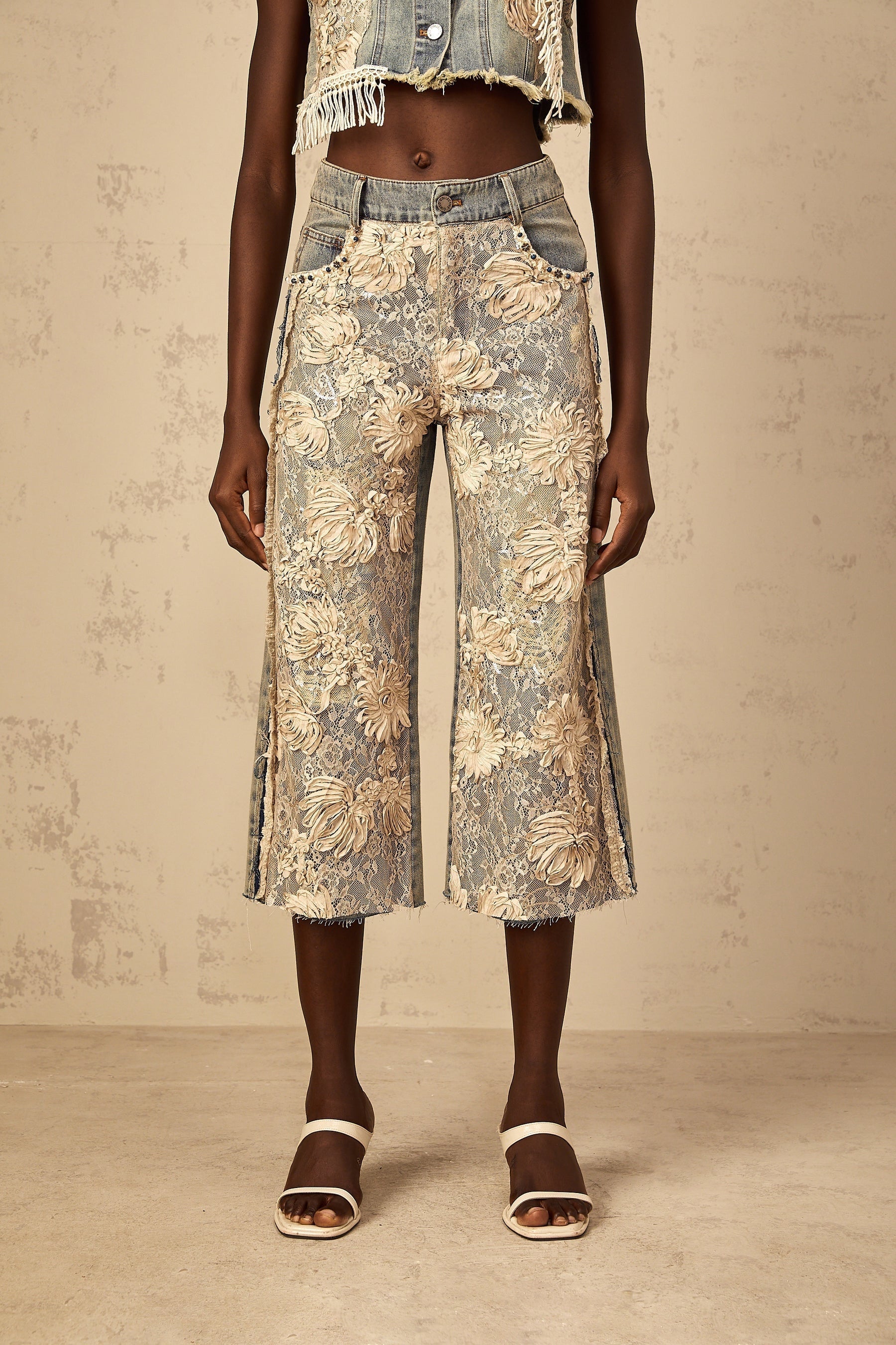 Blue denim jeans with floral lace panels in an amaryllis pattern