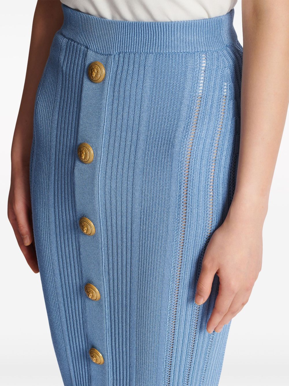 Blue high-waisted midi skirt with vertical ribbed texture and gold buttons