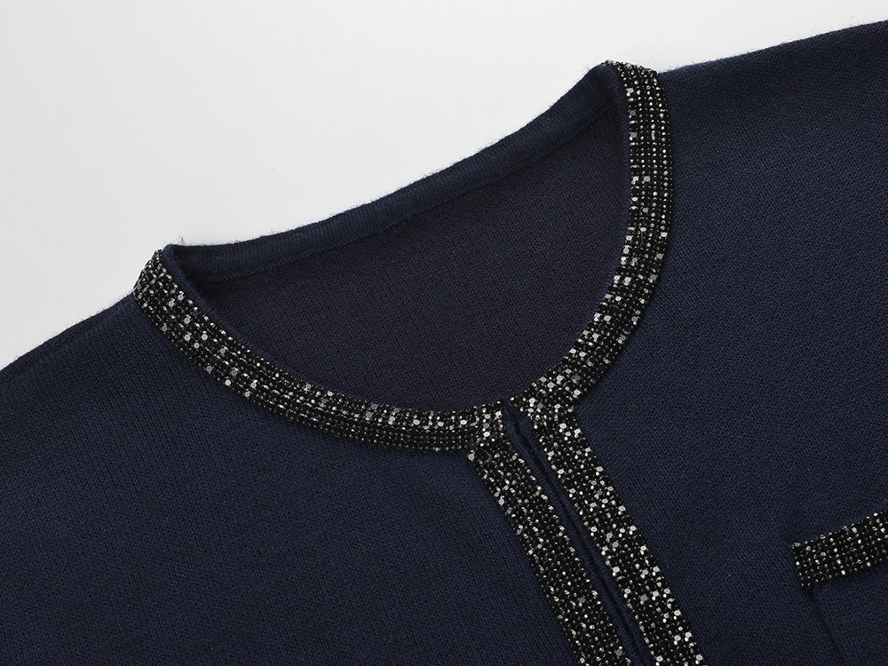 Blue knit two-piece suit with decorative buttons and embellishments