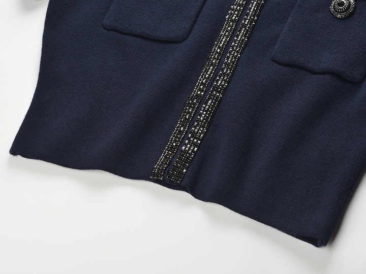 Blue knit two-piece suit with decorative buttons and embellishments