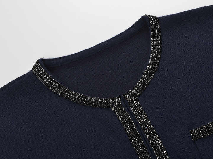 Blue knit two-piece suit with decorative buttons and embellishments