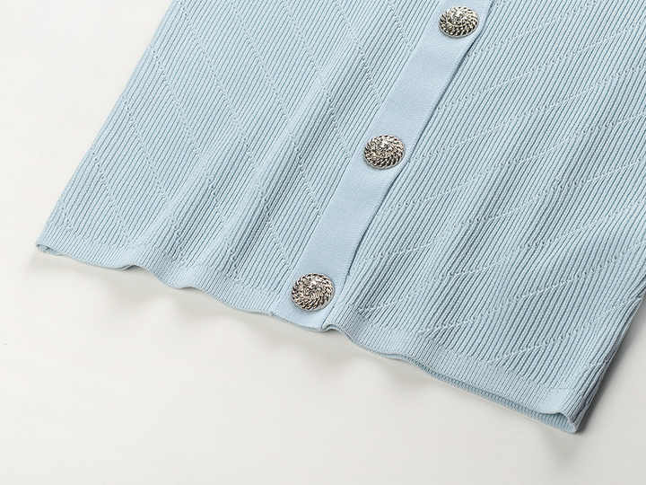 Blue ribbed knit button-front top with metallic buttons and pocket accents
