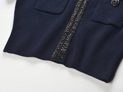 Blue tailored two-piece suit with decorative buttons and embellishments