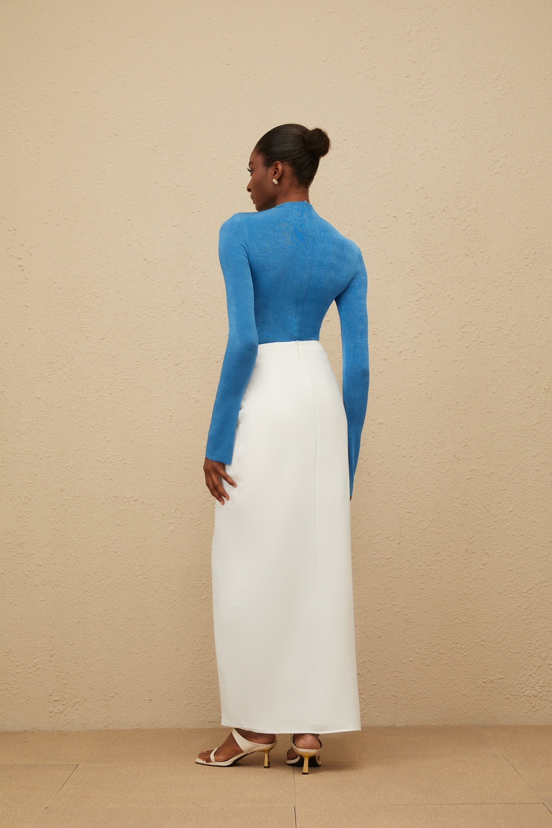 Blue turtleneck bodysuit with long sleeves and rear zip fastening