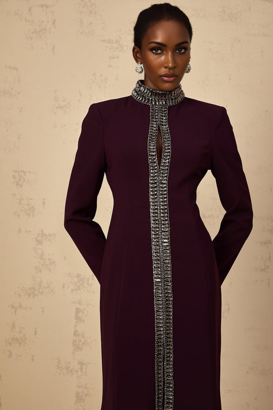 Burgundy maxi dress with flared skirt and embellished details on a model