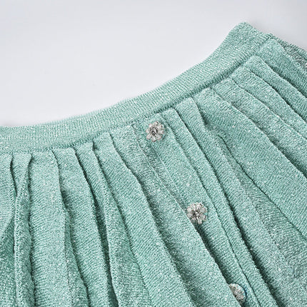Clara wearing mint green tweed jacket and pleated skirt set with floral embellishments and pearl buttons