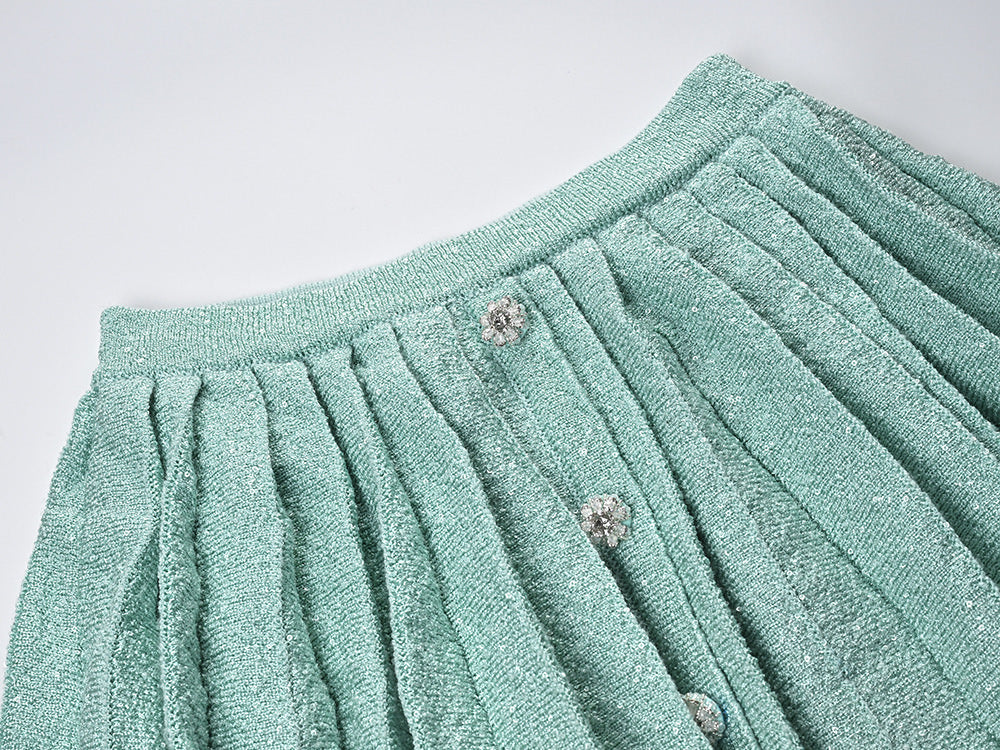 Clara wearing mint green tweed jacket and pleated skirt set with floral embellishments and pearl buttons