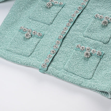 Clara wearing mint green tweed jacket and pleated skirt set with floral embellishments and pearl buttons