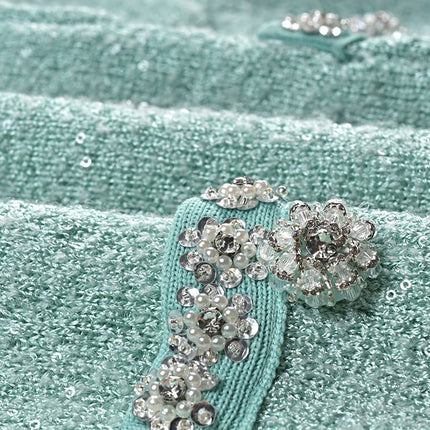 Clara wearing mint green tweed jacket and pleated skirt set
