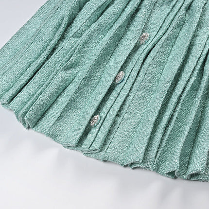 Clara wearing elegant mint green tweed jacket and pleated skirt set with floral embellishments and pearl buttons