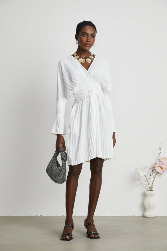 Claudette White Pleated Mini Dress V-neckline Flared Pleated Cuffs Long Sleeves Textured Finish Lacing Detail Cinched Waist Luxurious Blend Polyester Cotton Light Airy Feel Flowy Mini Length Elegant Daywear Summer Occasions Chic Gatherings Versatile Timeless Piece