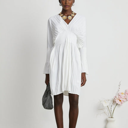 Claudette White Pleated Mini Dress V-Neckline Flared Cuffs Long Sleeves Textured Finish Lacing Detail Waist Defined Shape Luxurious Blend Polyester Cotton Light Airy Feel Elegant Daywear Summer Occasions Chic Gatherings Flowy Mini Length Versatile Timeless Piece
